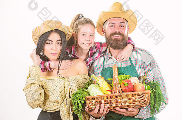 一个以秋收为荣的乡村农民家庭。在爱中成长。父母和女儿庆祝丰收。丰收节的概念。家庭农场主、园丁、蔬菜收获隔离白色背景。