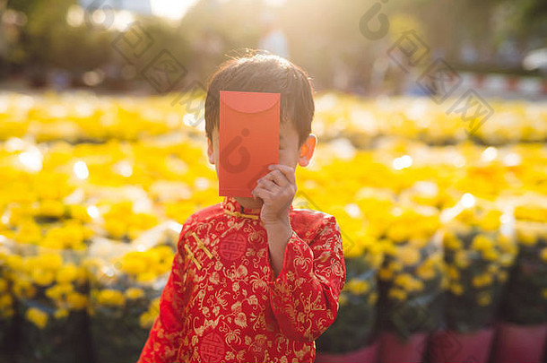 穿着传统节日服装的亚洲男孩肖像。可爱的越南小男孩穿着奥黛的连衣裙，面带微笑。春节假期。越南农历新年