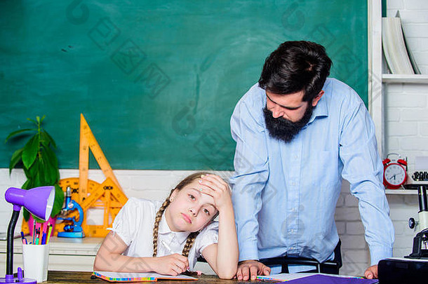 留胡子的男老师和疲惫的小女孩在教室里。女儿和父亲一起学习。教师节。回到学校。知识日。在家教育。教育儿童发展。我觉得很累。