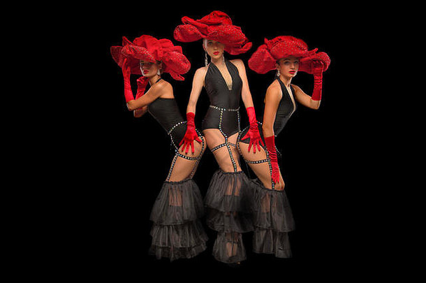 三位戴着红帽子的美丽歌舞舞者在黑色的舞台上相互隔离