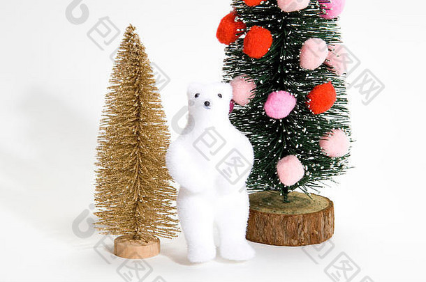 孤立的圣诞树上装饰着绒球，而不是旁边有金树和白熊的圣诞球。最小静物摄影