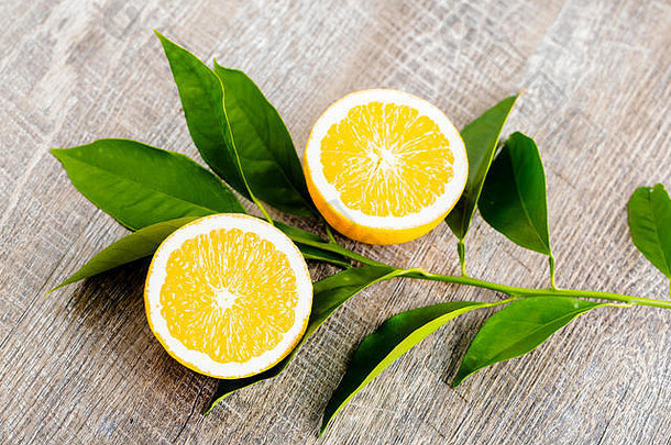 多汁的橙子切成两部分，橙花，橘子树的花朵，在乡村木背景上。橘子花是柑橘属植物的芳香之花