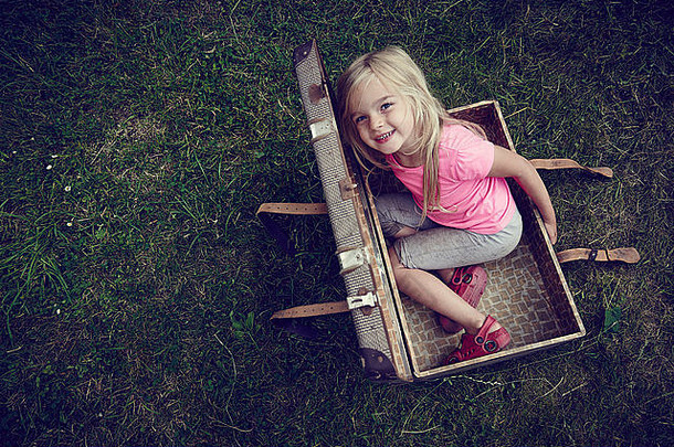 可爱的孩子金发碧眼的女孩玩内部古董手提箱
