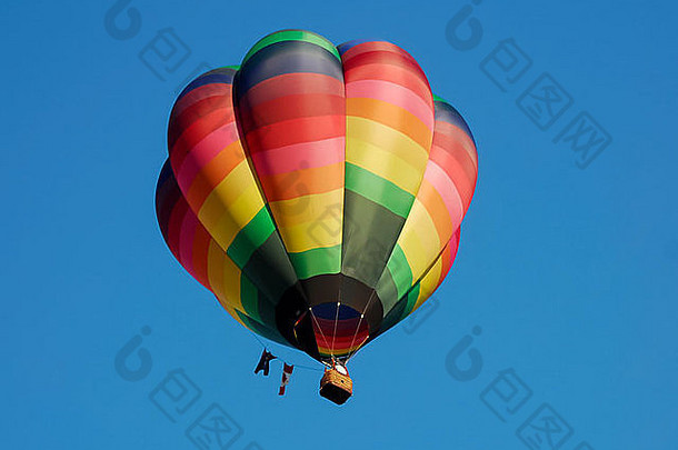 一个五颜六色的热气球映衬着深蓝色的天空。