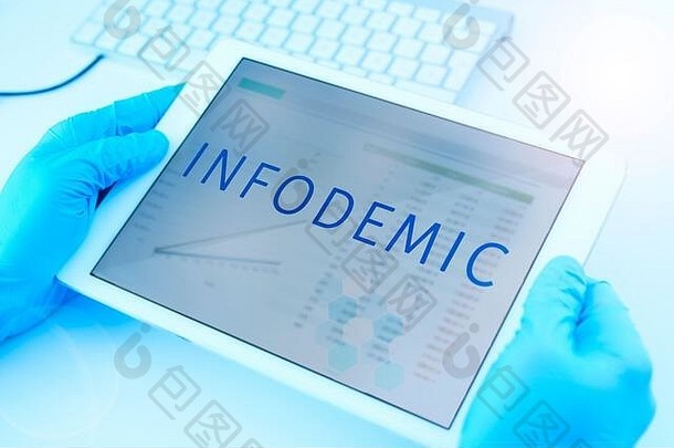 特写镜头：一名医生戴着蓝色手术手套，手里拿着一个屏幕上有“infodemic”字样的数字平板电脑
