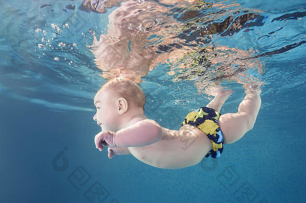 小男孩在游泳池里学习水下游泳。健康的家庭生活方式和儿童水上运动活动。儿童发展