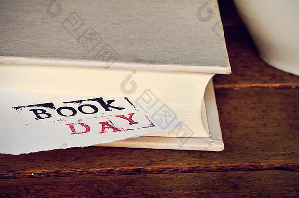 一张纸的特写镜头，一本书上突然出现了一天的教科书，放在一张简朴的木桌上，旁边是一杯咖啡