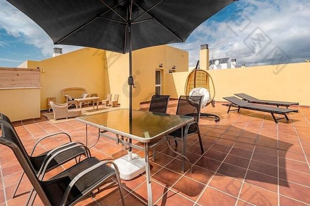 巨大的阳光明媚的阳台夏天假期财产挂椅子表格伞太阳床竹子沙发海视图