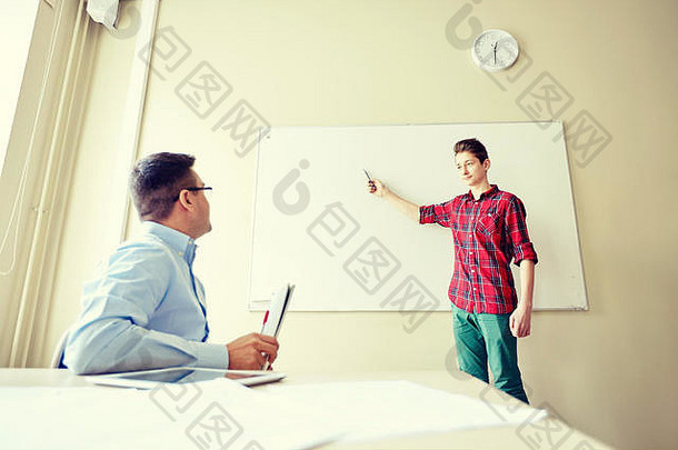 学生男孩在学校的白板和老师