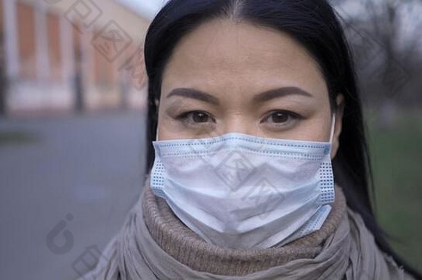 戴面具的亚洲女人站在户外，特写