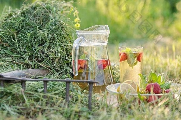 夏日<strong>清新</strong>的天然饮料，一壶一杯草上有草莓薄荷柠檬的<strong>花草</strong>茶，自然花园背景，健康的李