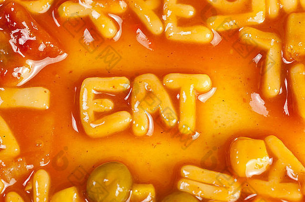 字母形状的意大利面形成词吃番茄酱汁
