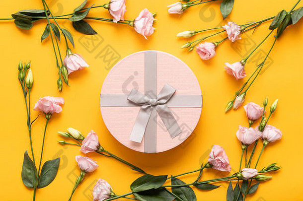 母亲节、妇女节、情人节或生日快乐黄色和淡粉色背景。带精美礼品盒的扁平贺卡