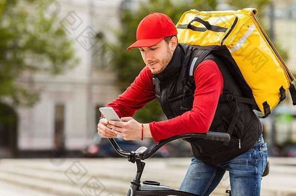 快递员使用手机在城市自行车上递送订单