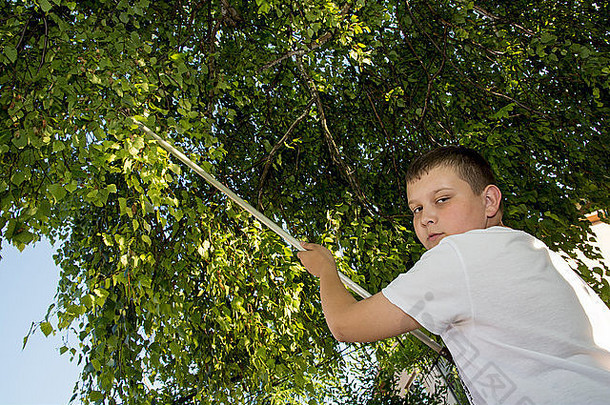 年轻的高加索人男孩减少树分支机构长修枝剪