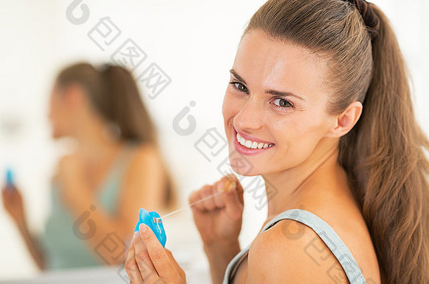 戴牙线的快乐年轻女子画像