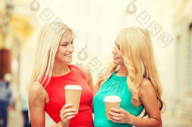 城市里两个拿着外卖咖啡杯的女人