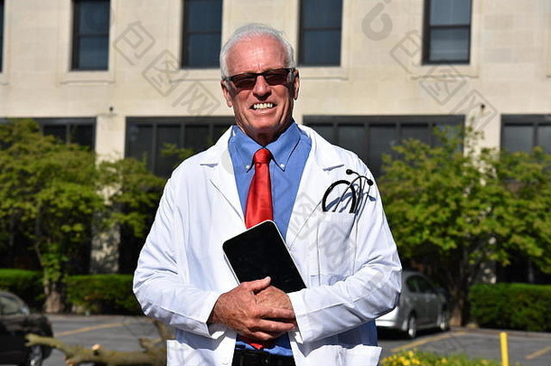 在医院里，一位面带微笑的英俊男医生穿着带药片的实验服