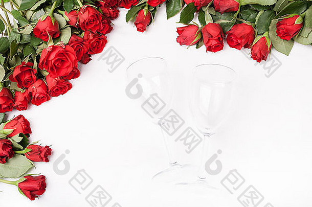 背景为红玫瑰和白葡萄酒杯