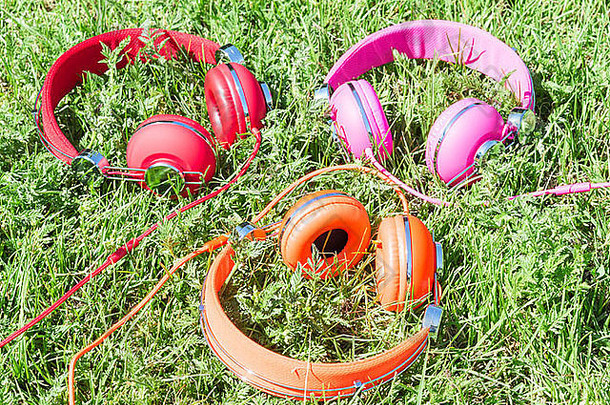 集五颜六色的色彩斑斓的耳机阳光新鲜的绿色草地