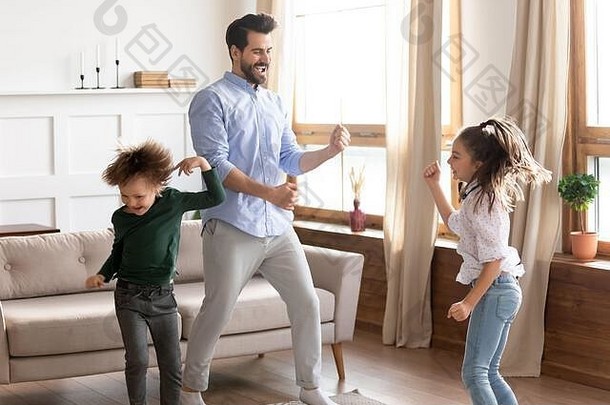 欣喜若狂的爸爸和孩子们在家里跳舞很开心