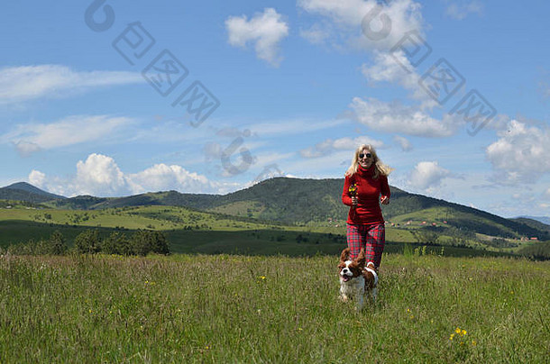 快乐金发女郎女人<strong>红色</strong>的狗骑士王查尔斯猎犬草地可爱的景观