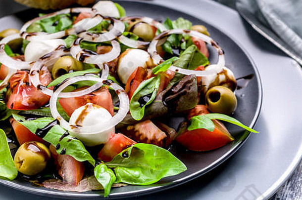 Food banner美味沙拉，由新鲜香草、马苏里拉、西红柿、橄榄、洋葱和香脂酱制成。意大利传统菜肴。叉