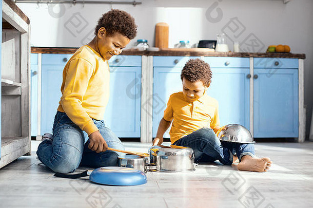 快乐的孩子们在厨房的平底锅上打鼓