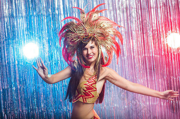 狂欢节肚子跳舞假期概念美丽的女桑巴舞者穿黄金服装微笑