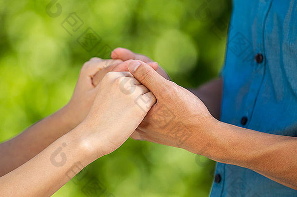 特写镜头水平照片年轻的成人夫妇持有手模糊绿色森林背景