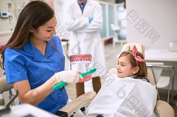女牙医向孩子示范如何正确刷牙