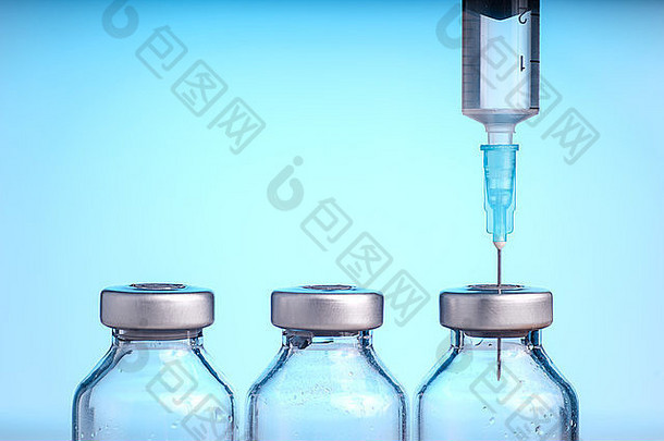 蓝色背景上隔离的医疗瓶和注射器