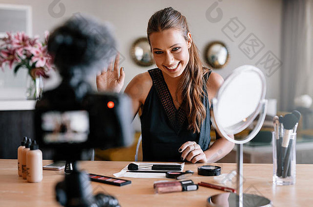 女人使视频博客化妆品微笑年轻的夫人面对记录相机化妆品项目表格