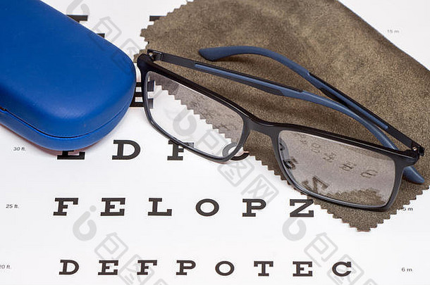 阅读黑色的眼镜棕色（的）超细纤维清洁布蓝色的保护情况下白色眼睛图表特写镜头