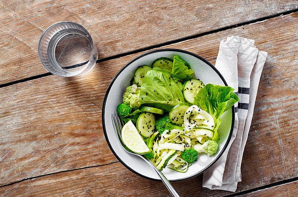 碗新鲜的绿色蔬菜沙拉木表格前视图