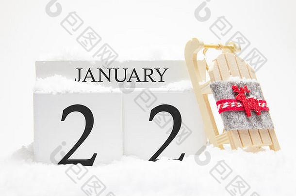 一月份的木制日历，冬季月份的第22天。冬天的象征是雪和雪橇。假期、假期和冬季乐趣的概念。
