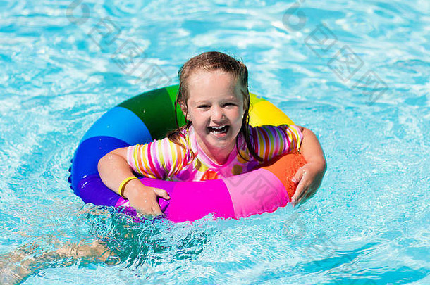 快乐女孩玩色彩斑斓的充气环户外游泳池热夏天一天孩子们学习游泳孩子们穿太阳protectio