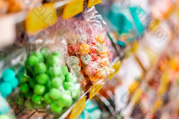 英国马特洛克一家糖果店的货架上，绿色、红色和黄色的糖果和<strong>糖果包装</strong>在一起，看起来很可口