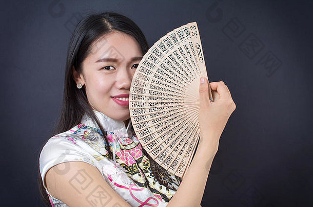 美丽的亚洲女人持有手风扇