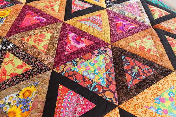拼布被子。作为背景的拼凑棉被的一部分。手工制作的。彩色毯子。