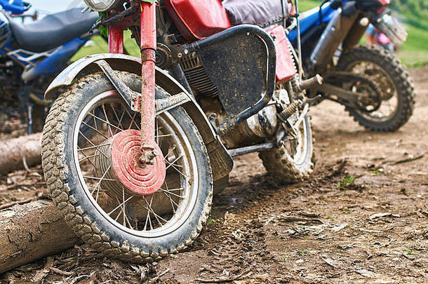 越野山地摩托车或参加摩托车大赛的自行车停放在肮脏的道路上