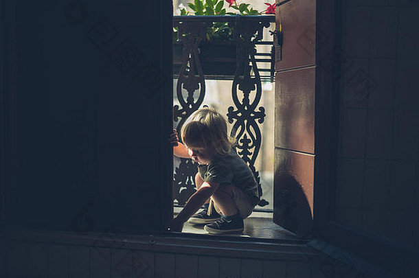 一个蹒跚学步的小孩正在阳台上玩耍