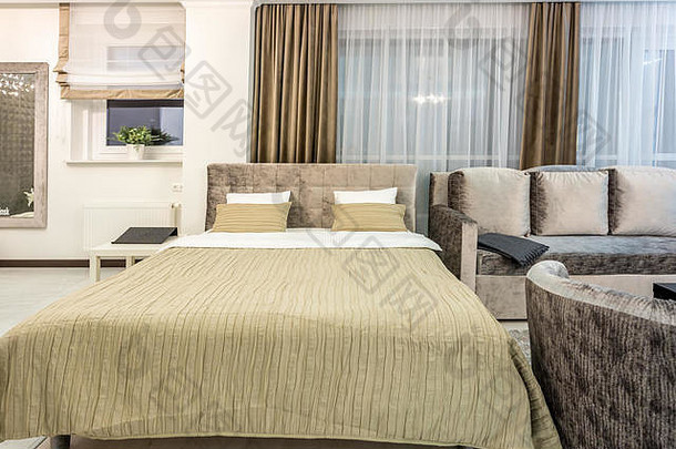 白俄罗斯明斯克—2018年12月：阁楼公寓的现代卧室内有带枕头的双人床，颜色较浅，属于高档公寓