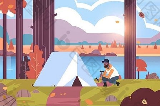 非洲男人。徒步旅行者露营者安装帐篷准备野营徒步旅行概念日出秋天景观自然河山背景平