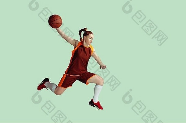 年轻的白人女<strong>篮球</strong>运动员在运动中，跳高动作孤立于薄荷色背景。运动、运动、活力和健康生活方式的概念。训练，练习。