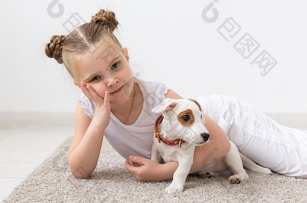 童年宠物狗概念乳头孩子女孩摆姿势地板上小狗