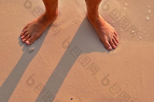 日出时在海滩上的脚