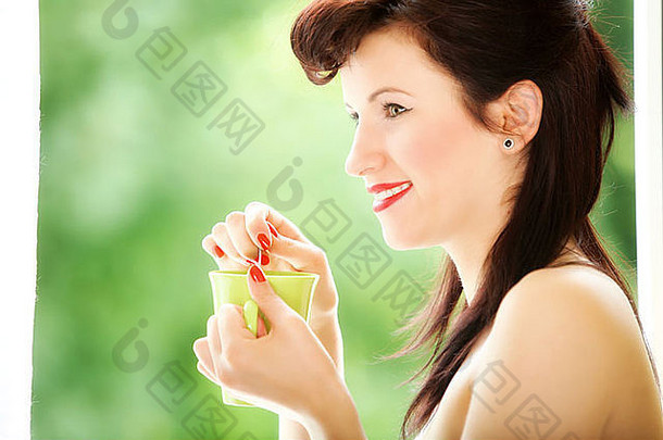 美丽的女孩复古的风格喝茶咖啡杯热饮料绿色长途跋涉背景