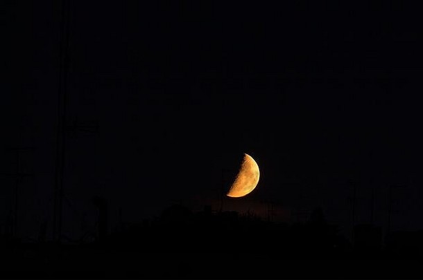 半个巨大的红色月亮的夜景