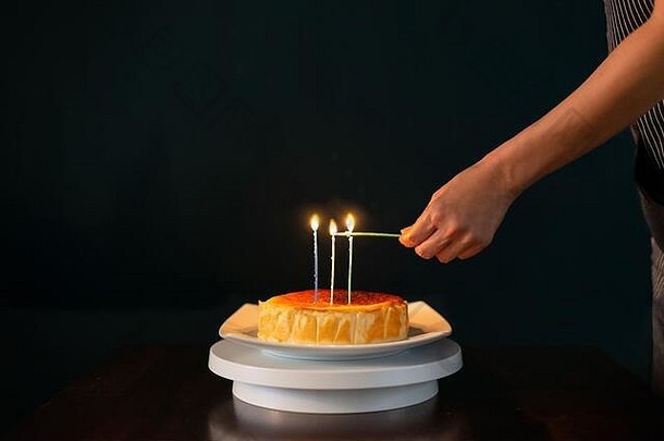 手基斯蜡烛生日蛋糕孤立的黑色的背景